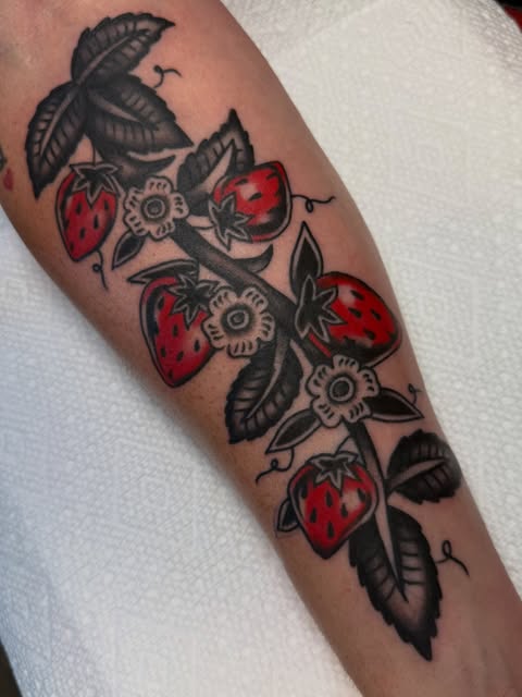 Traditional black and red strawberry branch tattoo