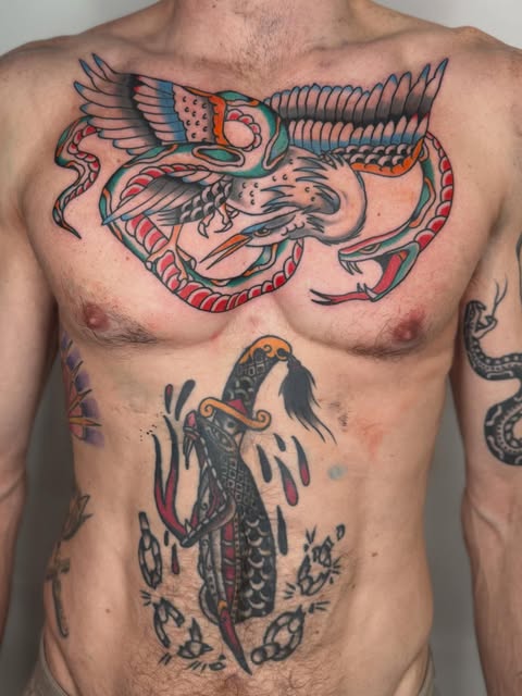 Large traditional bird and fish tattoos across the chest and torso