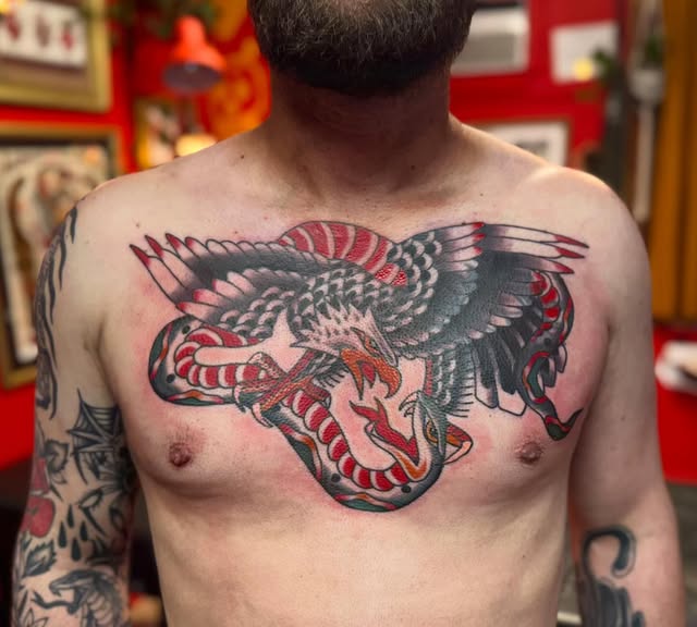 Traditional eagle and snake chest tattoo in black and red