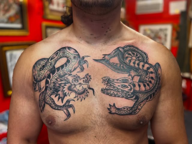 Paired black and gray dragon chest tattoos